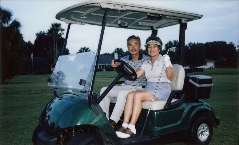 A couple enjoying a golf cart ride in retirement